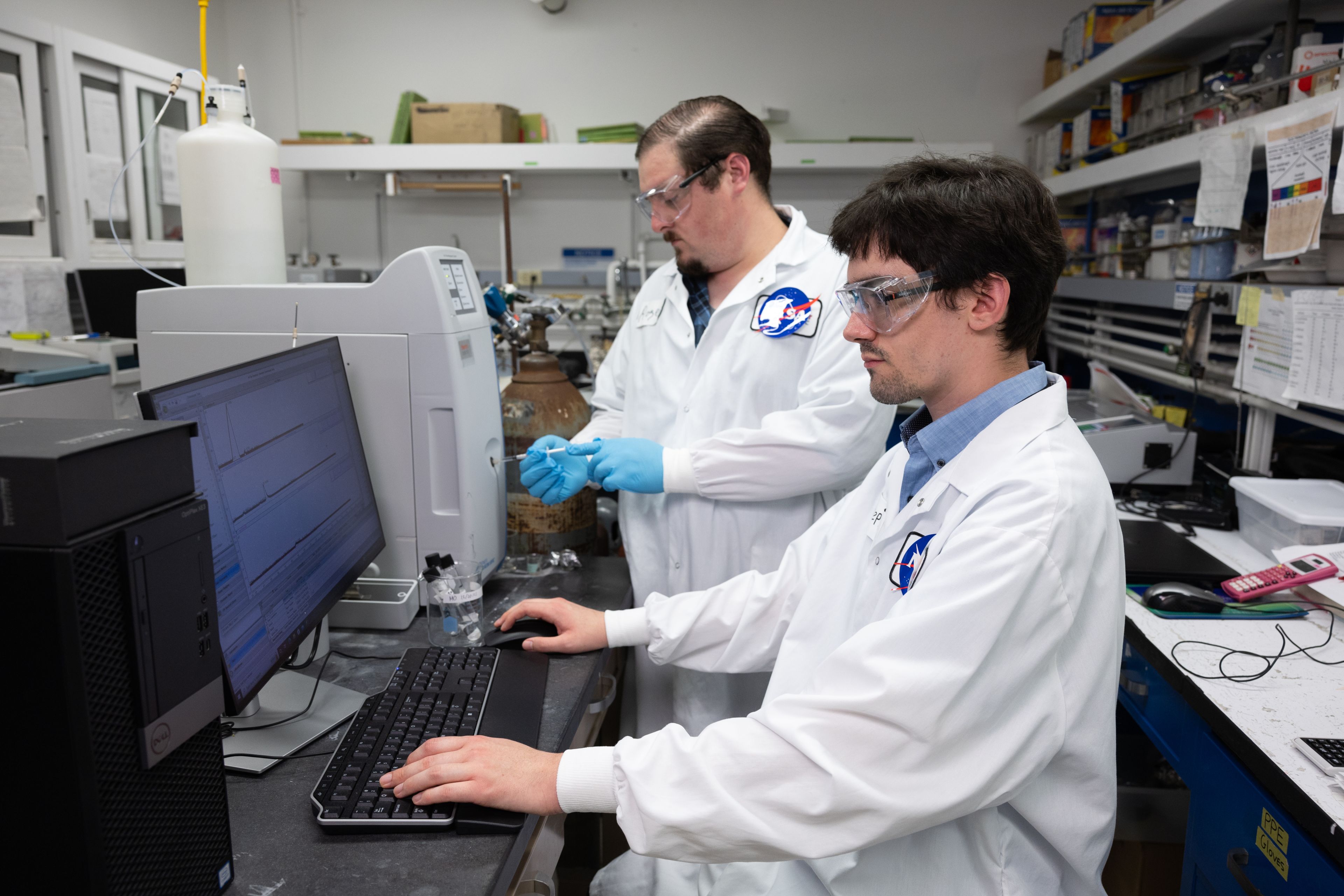 Two student interns, Stephen Ball and Roger Boucher, working in lab coats at the computer in the NASA lab. Astrobiology Scholars Program Immersive Research Experience (ASPIRE) , NASA, astrobiology