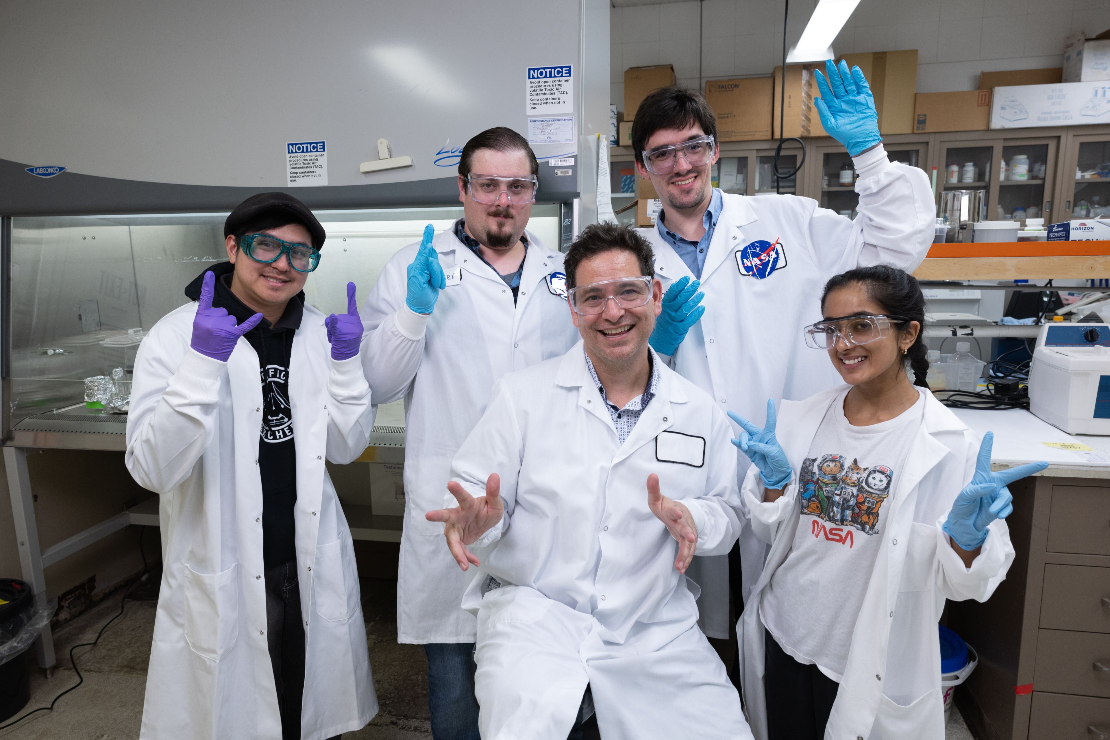 Andro Rios with several of the ASPIRE interns in a NASA lab, posing in labcoats. Astrobiology Scholars Program Immersive Research Experience (ASPIRE), NASA, astrobiology