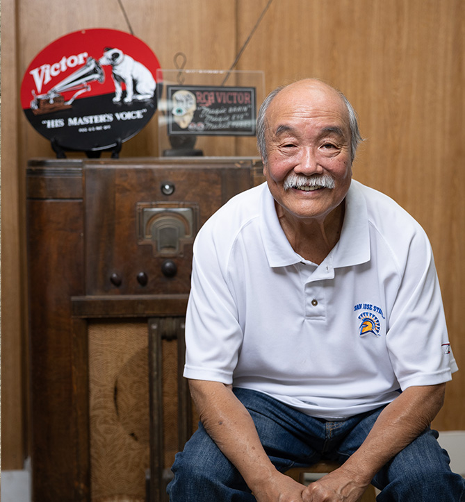 Robert Kumamoto seated in front of a VCA radio at Kogura Gifts shop, image by Jim Gensheimer. Japantown, San Jose, historic radios