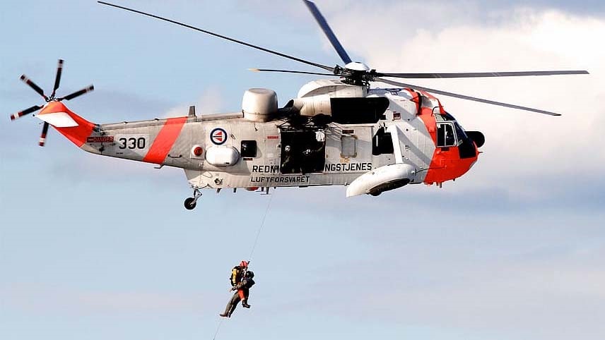 color image of a rescue helicoper reeling in a victim and rescuer