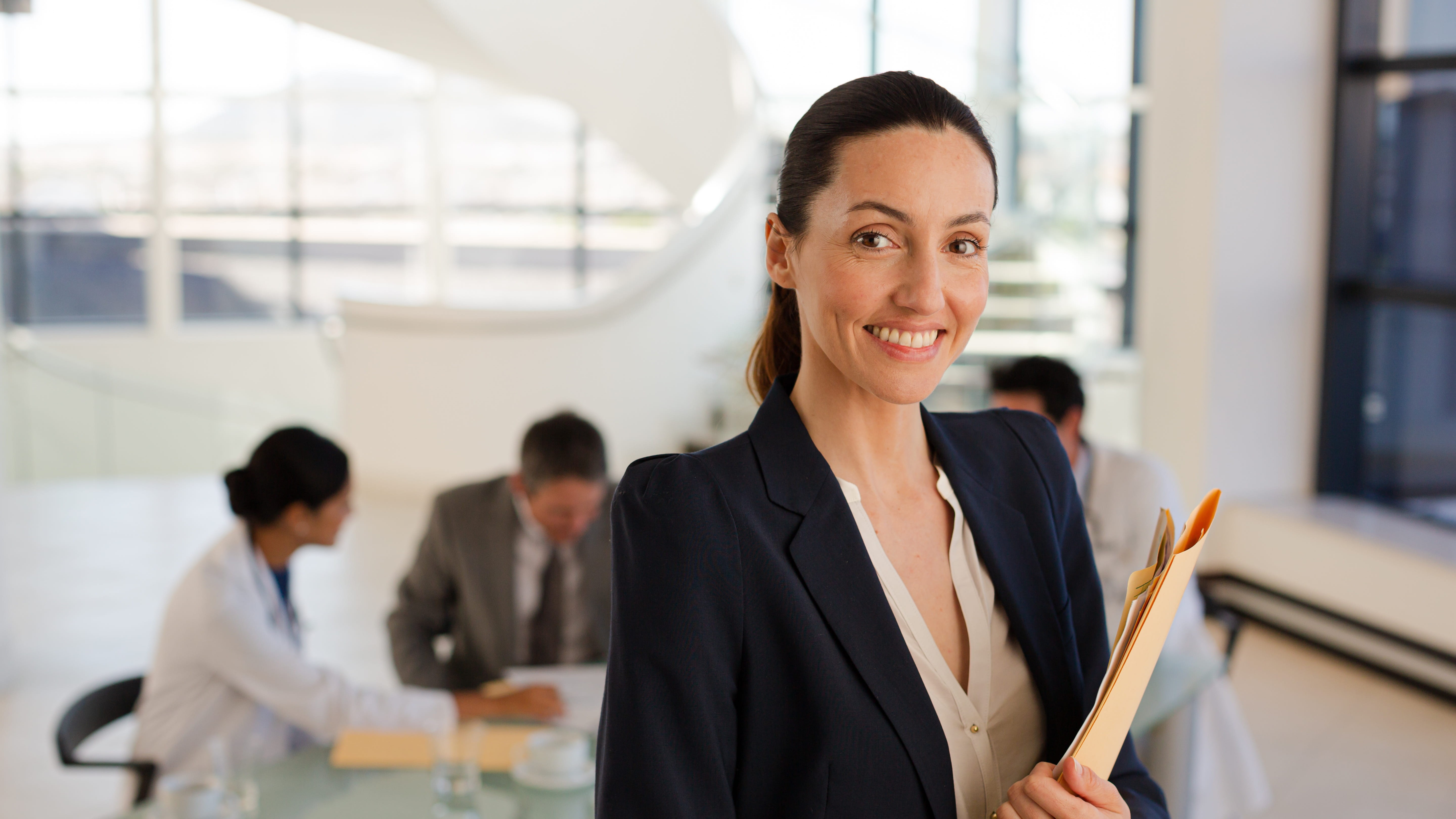 Woman smiling in meeting with medial professionals