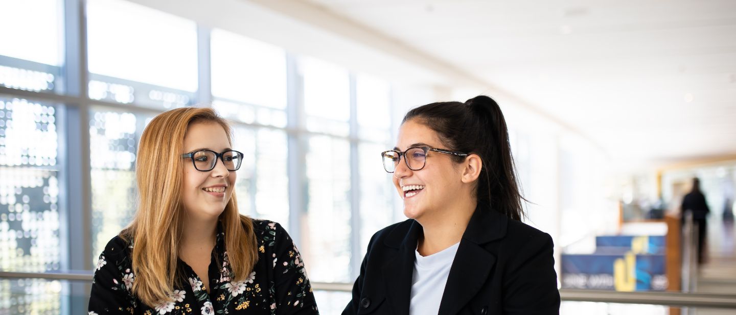 Two smiling people converse