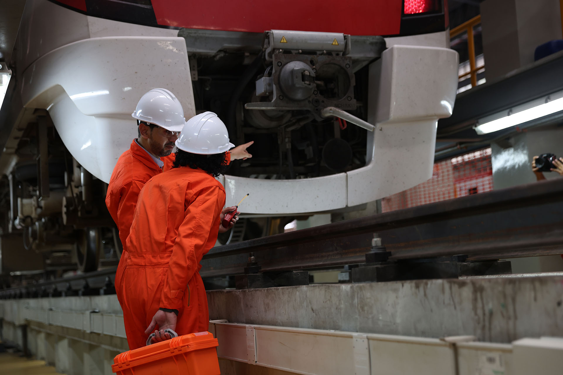 Male train engineers inspecting train