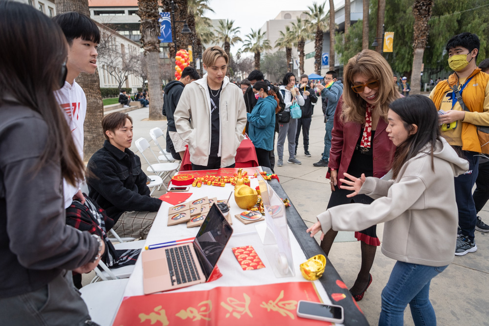 SJSU president speaking with students attending the Lunar New Year Celebration.