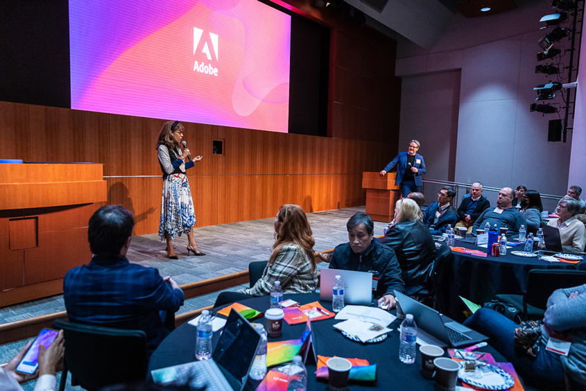 President Teniente-Matson standing on a stage at the Adobe headquarters.
