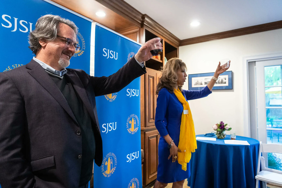 The president and the provost hold up a drink for a toast.