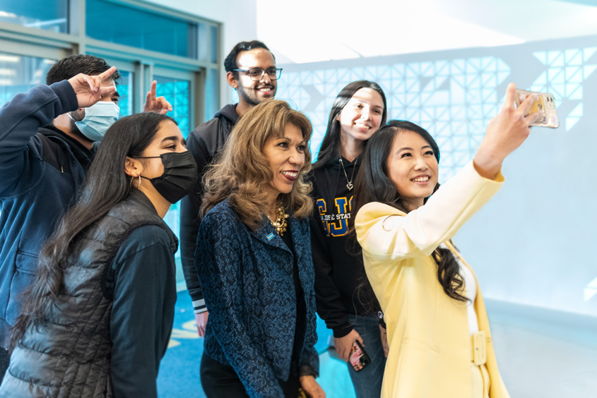 President Teniente-Matson taking a selfie with students.
