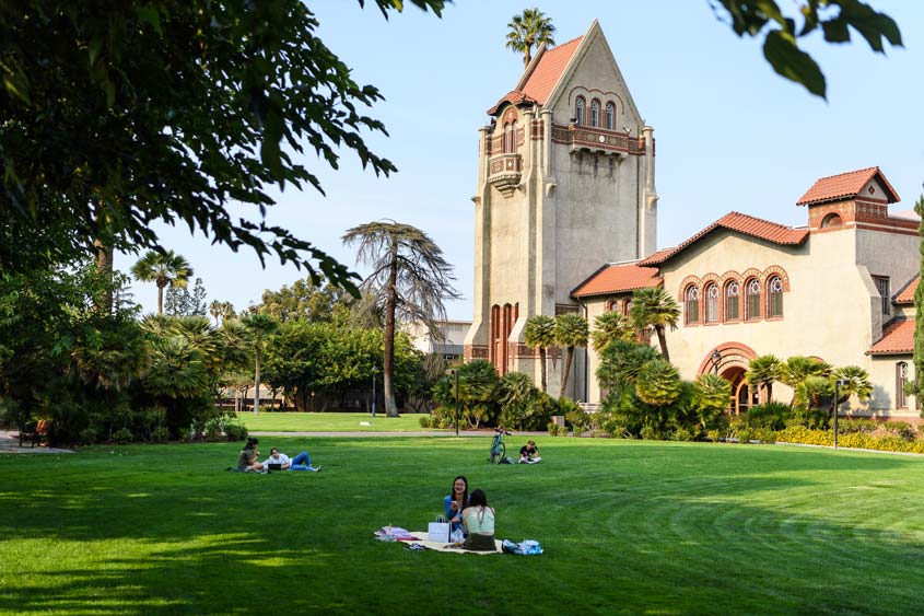 Students relaxing on the lawn next to SJSU's Tower Hall.
