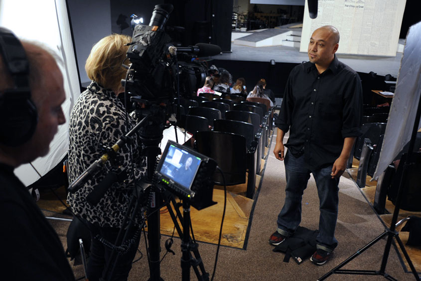 Faculty member in front of a camera crew.