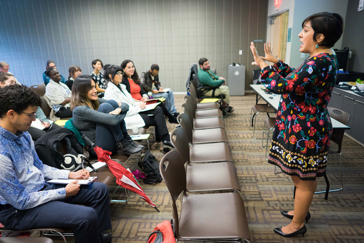 Magdalena L. Barrera speaking and gesturing with hands to an audience.