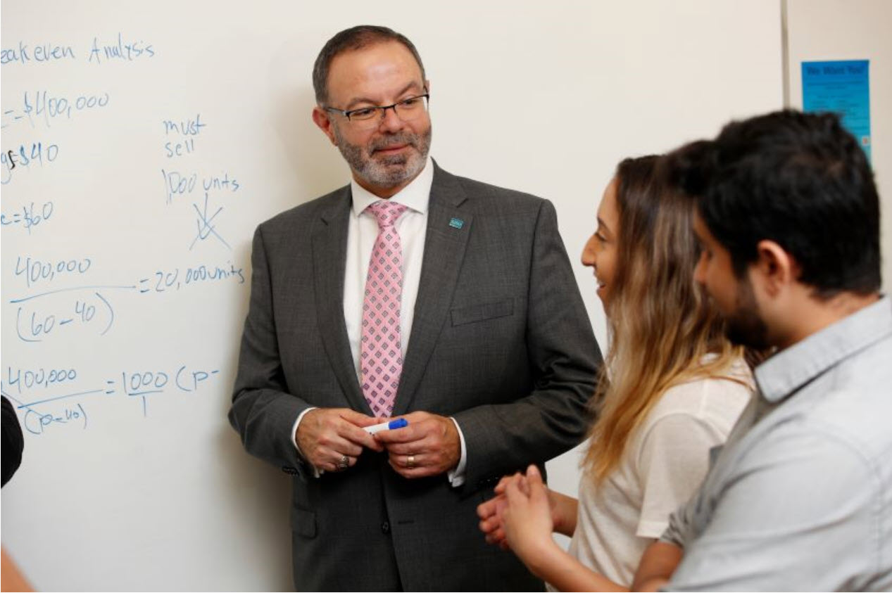 Dr. Abousalem with students in front of a white board.