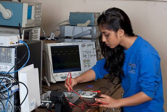 woman works on circuit board in a lab