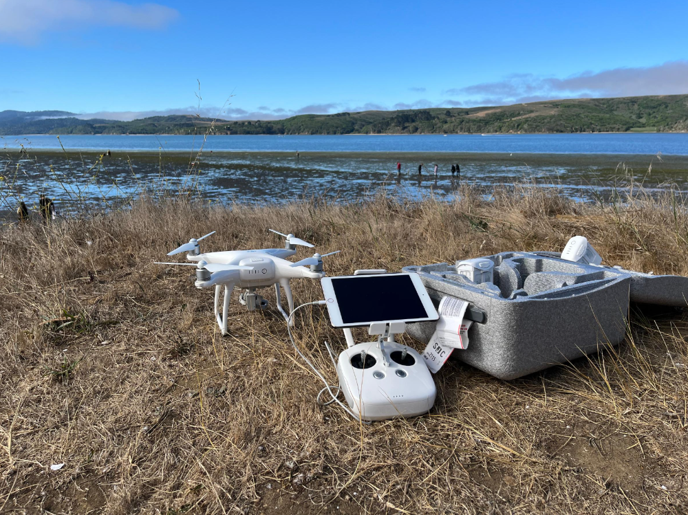 A picture showing drone and its remote controller placed on the ground