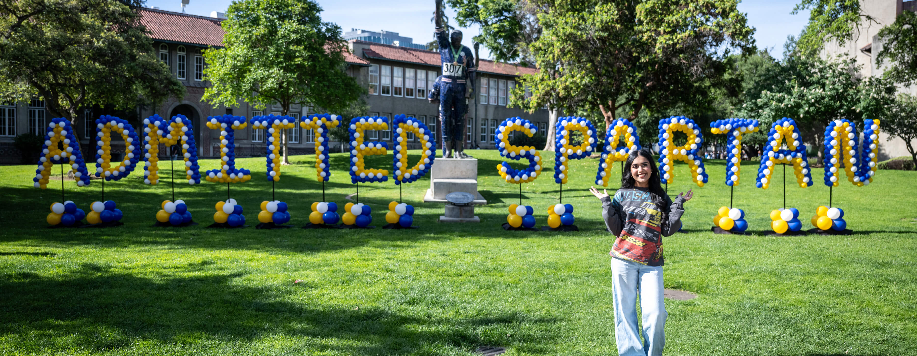 Student in front of Admitted spartan balloons