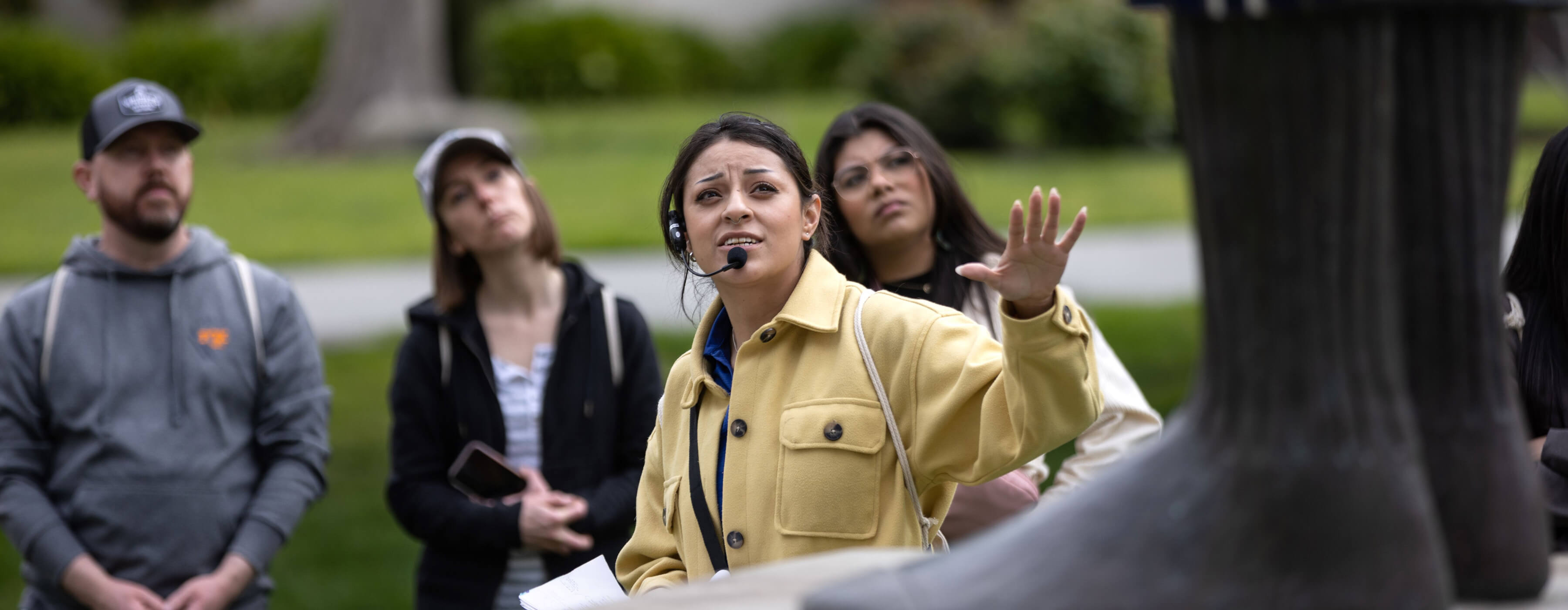 Student ambassador wearing a headset leading tour group on campus
