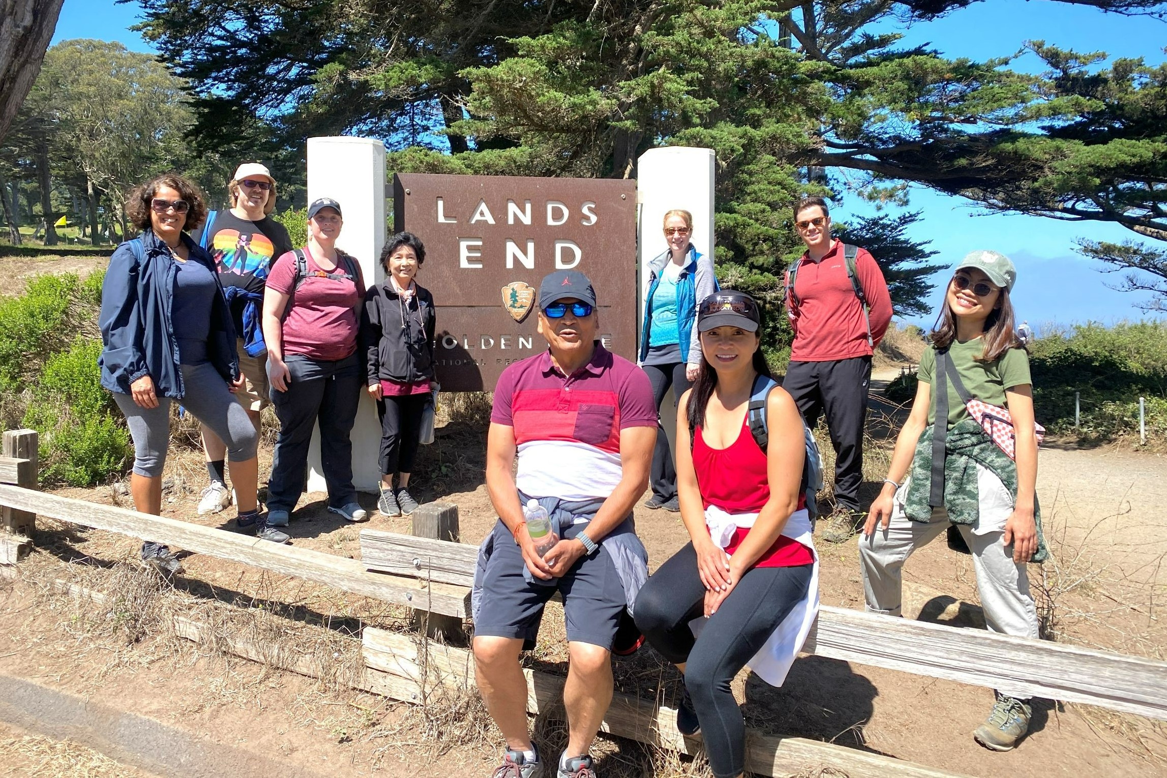 Group of staff standing near a sign that reads "Lands End."