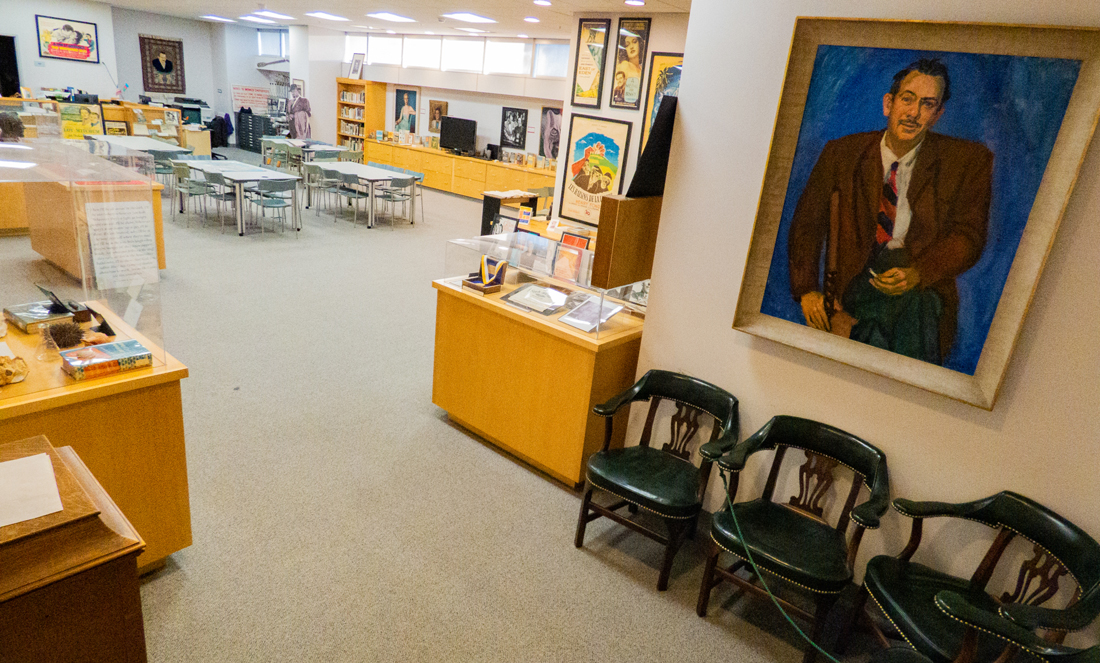 Interior of the Steinbeck Center in the MLK library showing bookshelves, displays, and artwork.