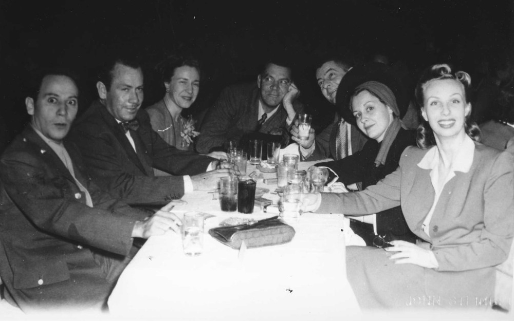 Steinbeck sitting at a table with friends