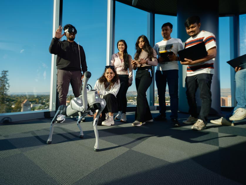 Student engineering students and researchers with a robot dog.