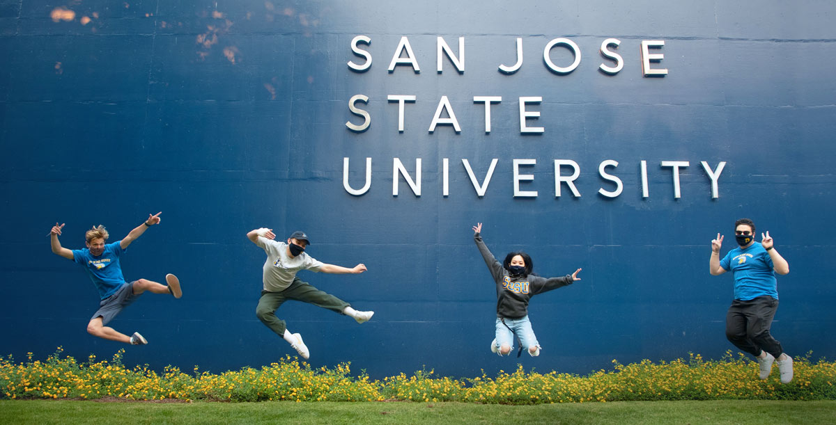 SJSU students in masks jumping up in the air.