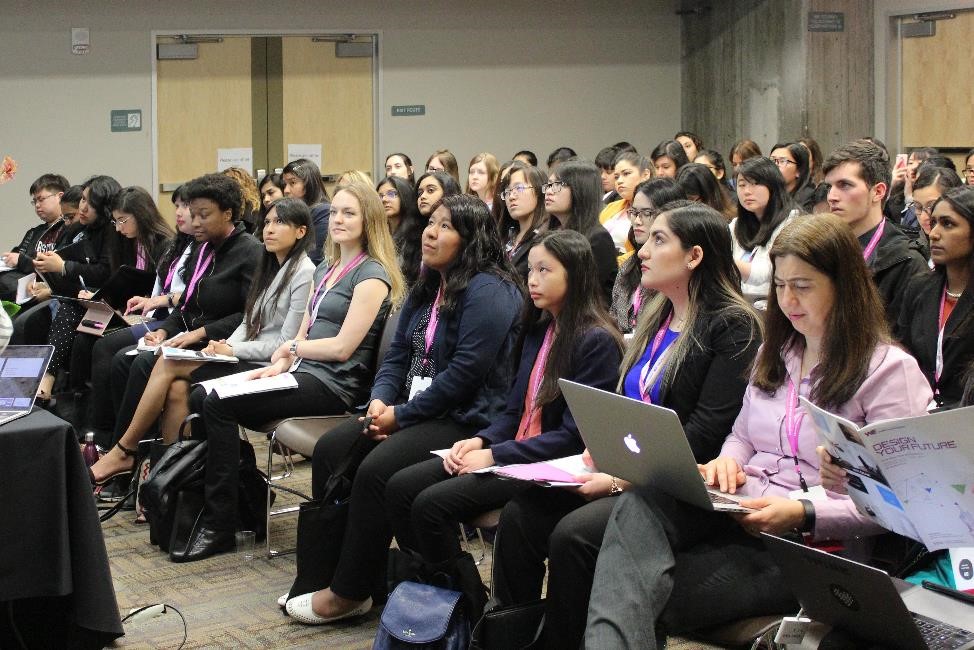 a diverse group of female students attend a conference lecture